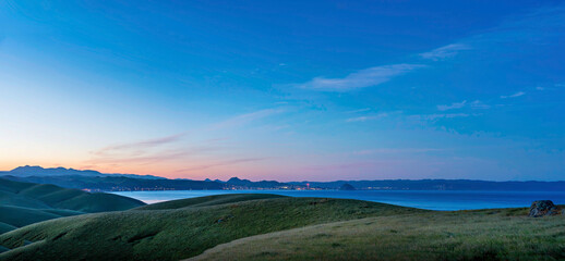 Panorama of sunrise, sunset over ocean and hills and coastline