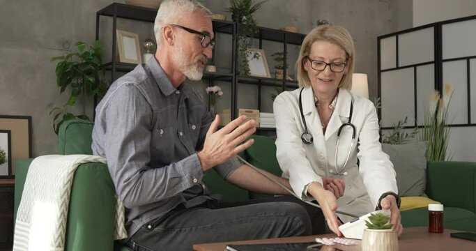 mature man have home visit by a doctor to measure his blood pressure