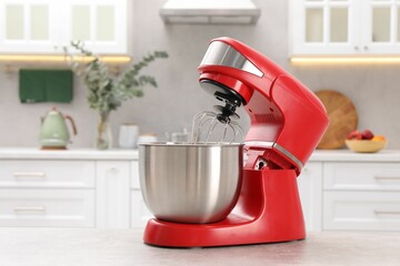 Modern red stand mixer on light gray table in kitchen, space for text