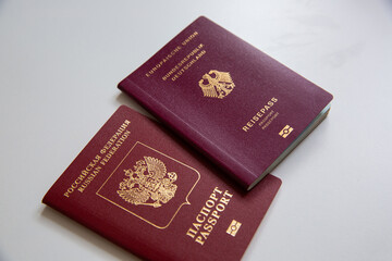 Close up of a German and a Russian passport on white table