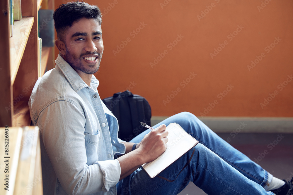 Poster male student, portrait and smile in library for study in university with notebook for education with