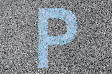 The Letter P is drawn with color paint on asphalt. display of the parking space