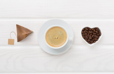 Cup of coffee made using pyramid on wooden background, top view