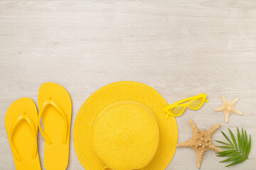 Flat lay with yellow summer outfit on wooden background. Vacation concept