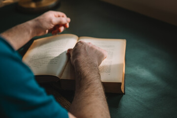 Books and reading. Reader behind an open book. mans hands turning the pages of a book in the...