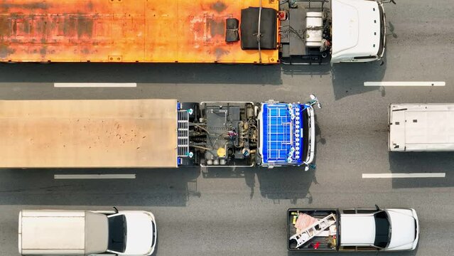 An aerial canvas reveals the intricate patterns of urban travel. Cars, buses, and a solitary motorcyclist form a colorful mosaic as they traverse the marked lanes, painting the road with motion.
