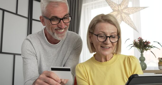 Mature caucasian husband and wife shopping online sit at home