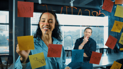 Smart businesswoman leader writing creative business idea while male caucasian investor listen...