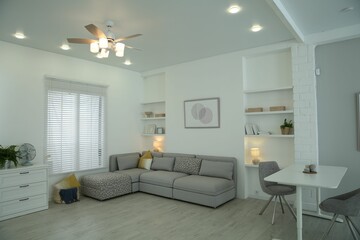 Comfortable furniture, ceiling fan and accessories in stylish living room