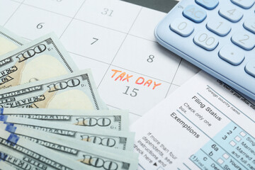 Tax day. Document, dollar banknotes and calculator on calendar with date reminder