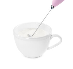 Whisking milk in cup with mini mixer (frother wand) isolated on white
