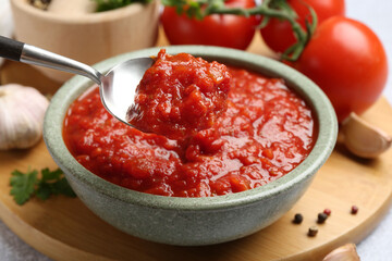 Eating homemade tomato sauce at light grey table, closeup
