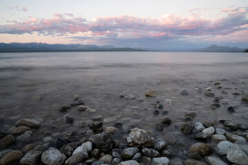 Long exposure shot of Nahuel Huapi lake at sunset. Beautiful blurred water effect, the rocky shore...
