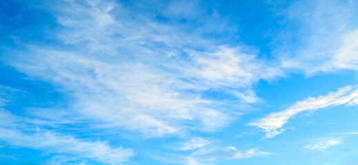 Blue sky background with white dramatic colorful clouds and soft sunlight