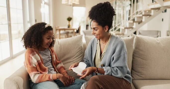 Mom, girl and home in sofa with sanitary pad for menstrual hygiene, education and awareness with information. Parent, kid and child development with support, care and teaching for life skills