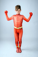 Young male cosplay superhero wearing red spandex costume showing his muscles and ready to fight...