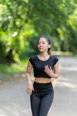 Healthy young female runner stretches her legs before running in the park. Woman exercising for...