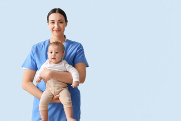 Female pediatrician with little baby on blue background