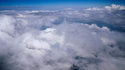 Flying over the clouds. Beautiful white foamy clouds seen from the plane