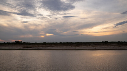 Panorama view of the calm river and shore under a magical sunrise sky