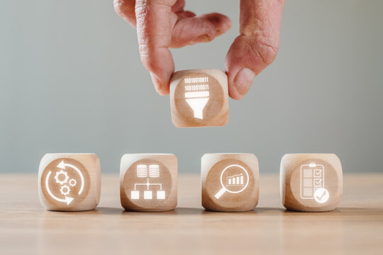 Data mining concept, Hand holding wooden block on desk with data sets, pre processing, database, analytics and evaluation icon on virtual screen.