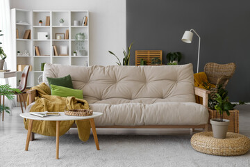 Interior of living room with soft couch, table and green plants