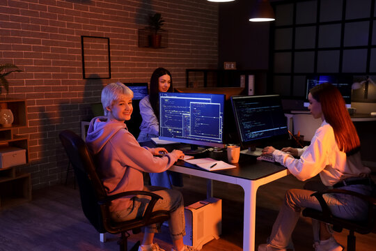 Group of female programmers working in office at night