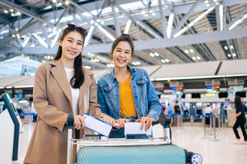 Portrait of Asian women standing in airport terminal at boarding gate.