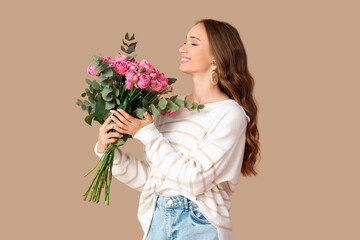 Beautiful young woman with roses on brown background