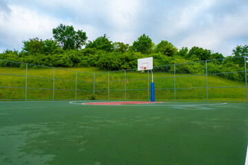 Outdoor basketball court in a park where people can enjoy playing and recreational activities.