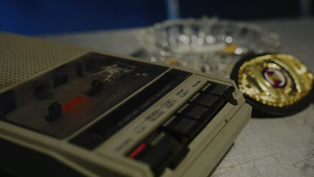 Zoom in on police badge and tape recorder