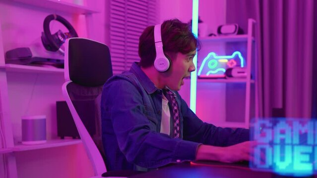 Asian e-sport man loser gamer playing online video game on computer. 