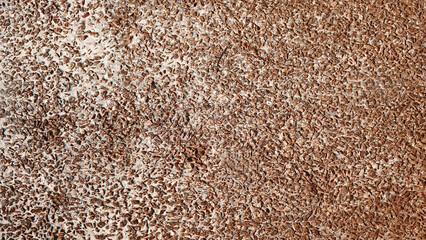 Concrete background or coarse flake stone mixed with small pebbles with a dark brown gradient. For...