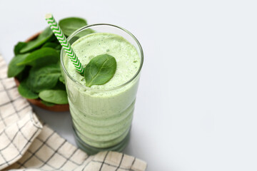 Glass of fresh spinach smoothie on grey background