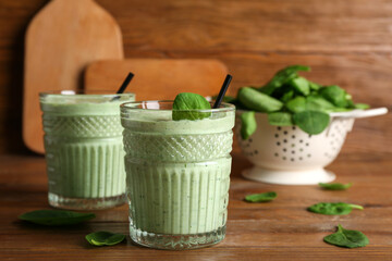 Glasses of fresh spinach smoothie on wooden background