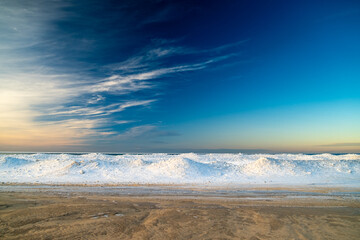 Ice dunes formed during winter in the lakeshore with Lake Michigan in background