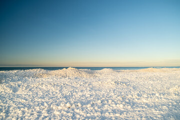 Ice dunes formed during winter in the lakeshore with Lake Michigan in background