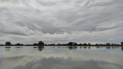 The refreshing view fish pond with the reflection of the sky during cloudy day