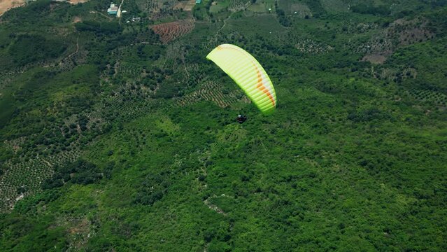 Extreme and active leisure. Man flies on an extreme paraglider in the Vietnamese mountains, the concept of freedom. Paraglider flies above the treetops. slow motion in 4K