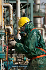 Worker handling chemical solutions in industrial setting, adhering to safety protocols.