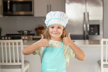 Portrait of funny child chef in kitchen. Portrait of funny child chef in kitchen. Kid chef cook cookery at kitchen. Cute boy cooking in kitchen at home kitchen. Healthy ingredients.
