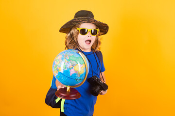 Kid with earth planet model hiking at nature. Little explorer. Child tourist on yellow background.