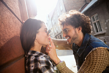 Happy couple enjoying a playful moment outdoors on city street