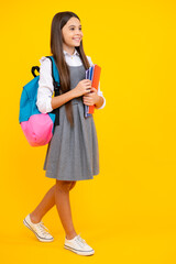 Back to school. Schoolgirl student hold book on yellow isolated studio background. School and education concept. Teenager girl in school uniform.