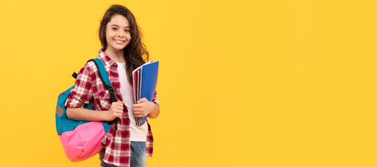 Happy girl back to school carrying books and backpack yellow background, school. Banner of schoolgirl student. School child pupil portrait with copy space.