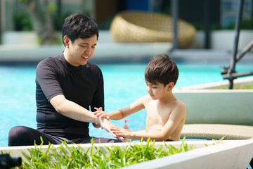 Man applying sunscreen lotion on child's body.