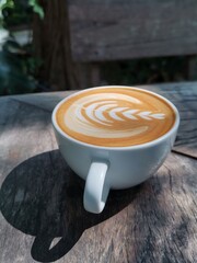 Latte art on brown wooden table