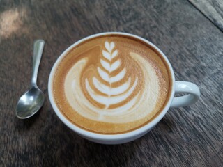 Latte art on brown wooden table