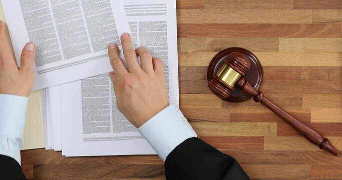 Judge knocking gavel and documents on table top view