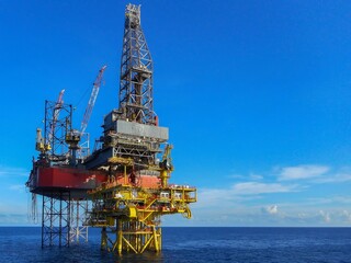 Drilling rig offshore oil field showing derrick, drill floor, crane, well slot platform, leg with...